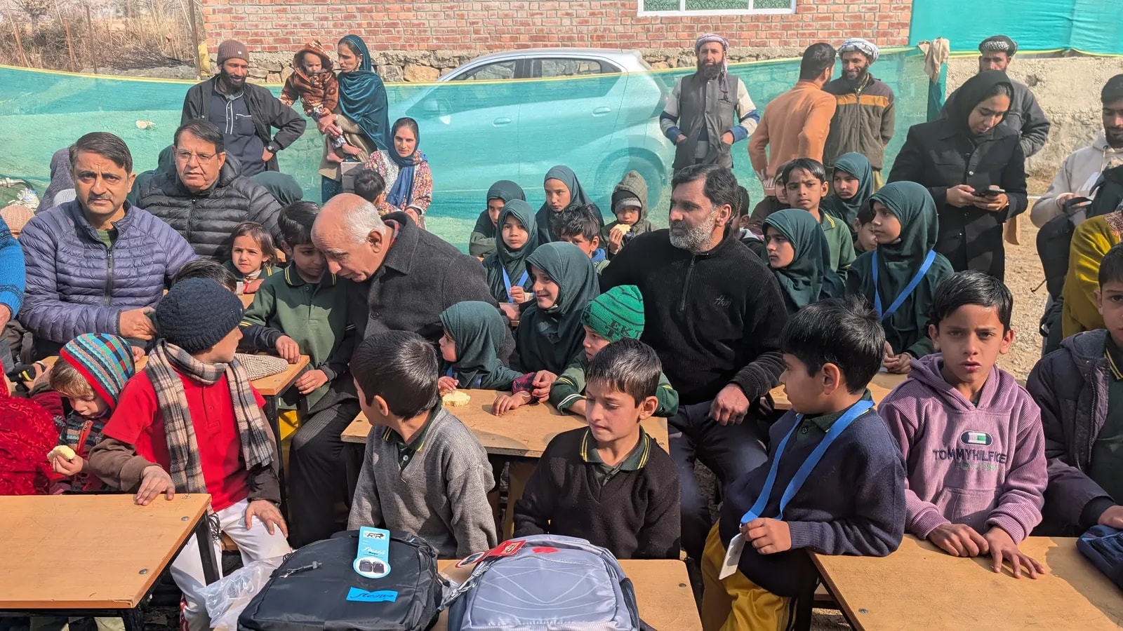 Guests sitting with students at their desks