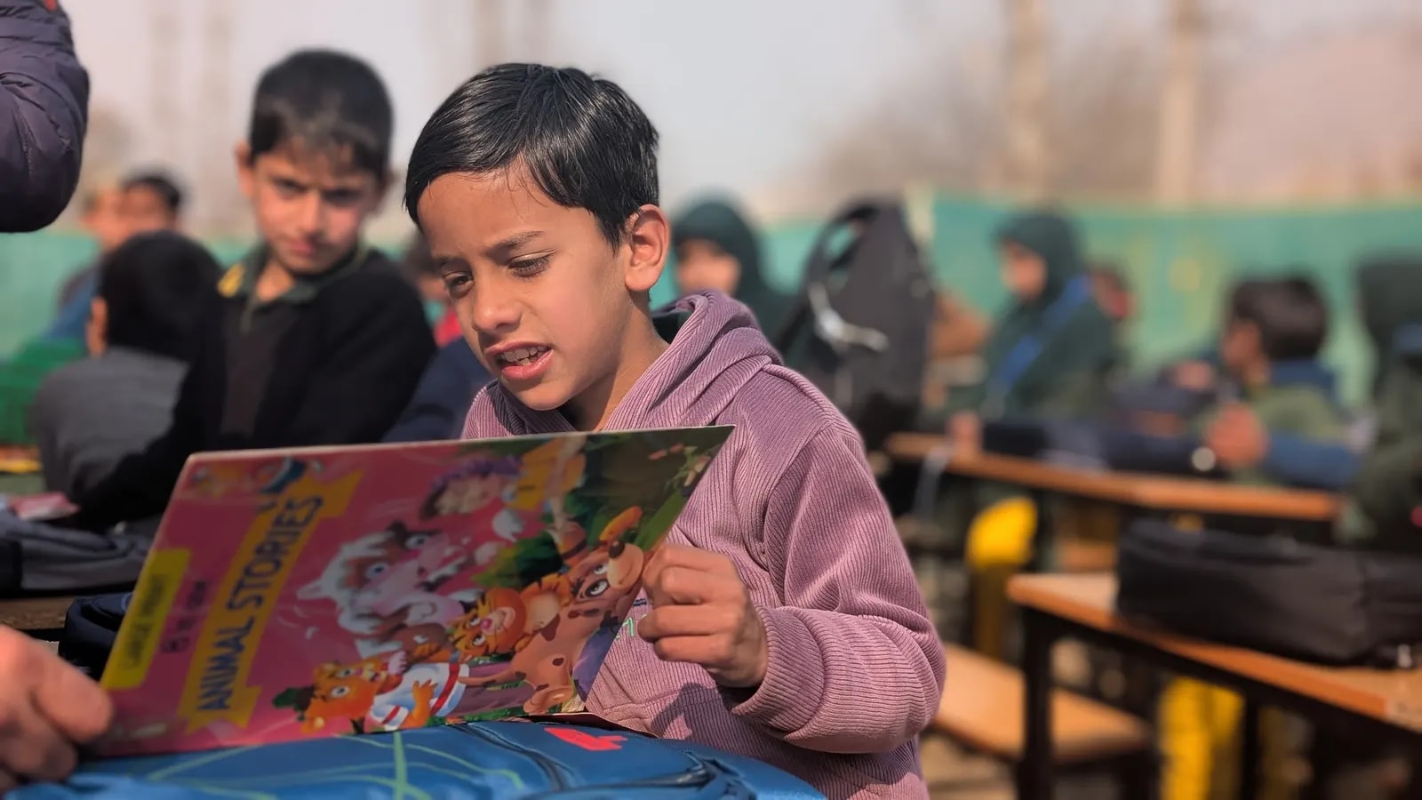 A student at the Bardalav government school reading a new storybook