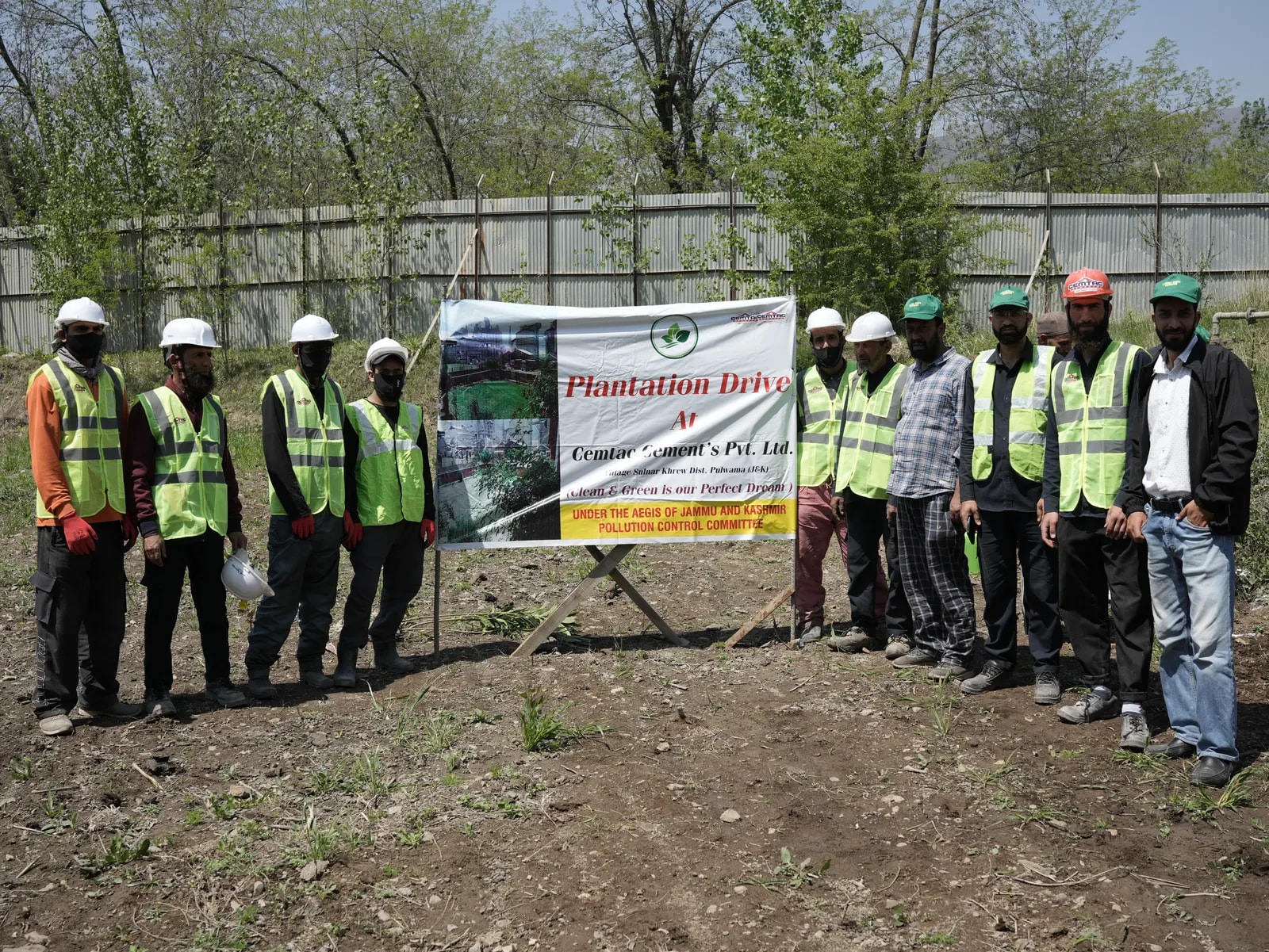 Cemtac staff and workers beside the Plantation Drive banner at the plant