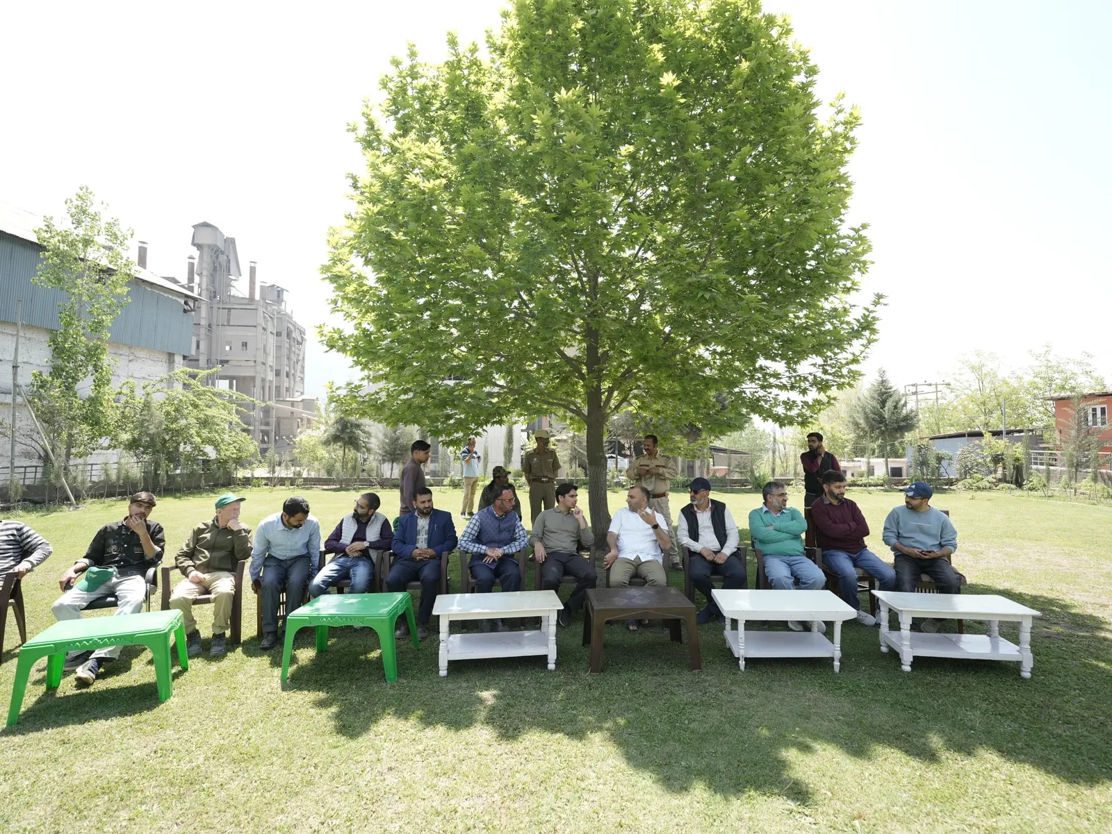 Guests gathered under a tree on the plant's lawn, with the plant in the background